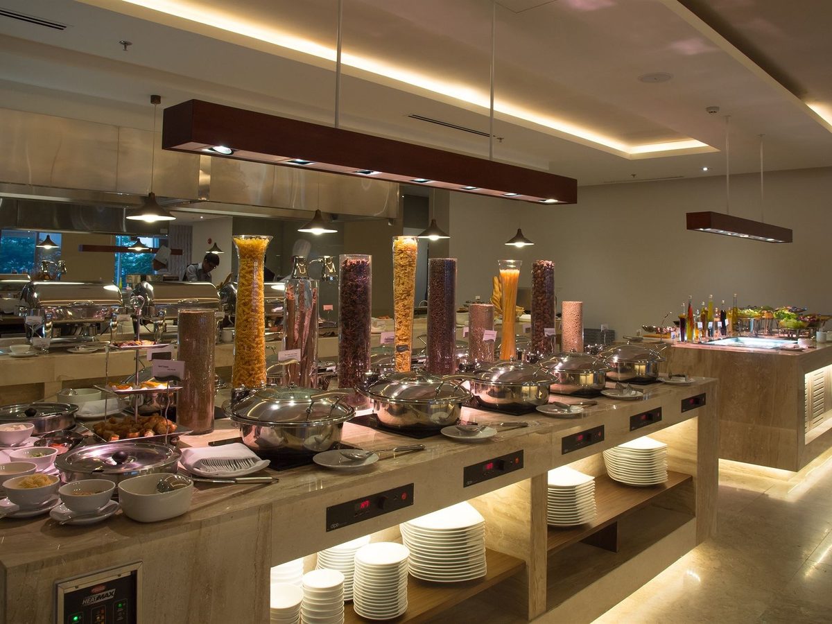 Long buffet counter with salads, desserts and cooking stations