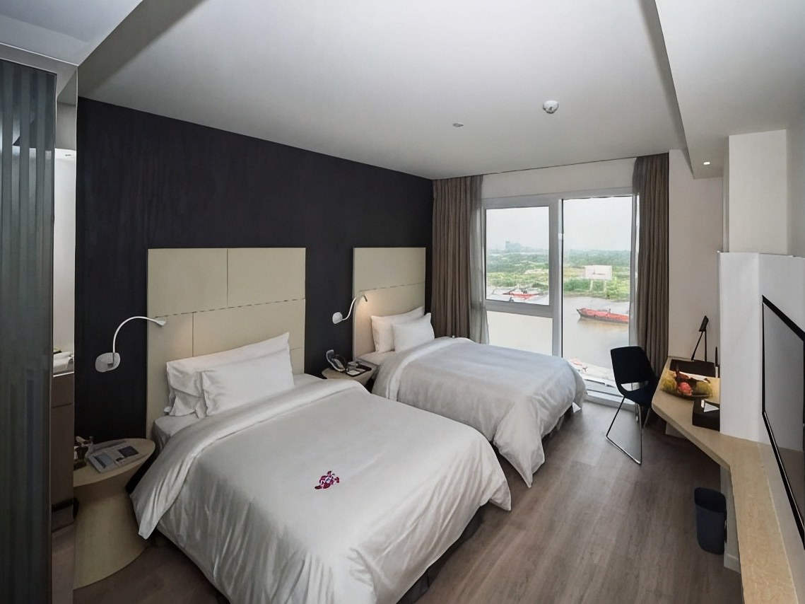 Twin room with two beds made up with white linen and a window