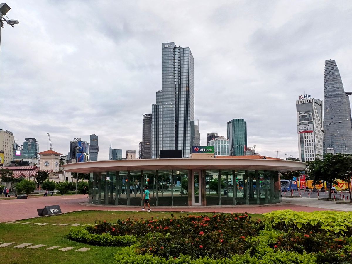 Modern metro train on an elevated track above a Saigon street