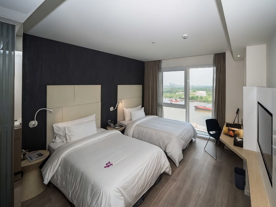 Twin room with two beds beside a window looking out over a river